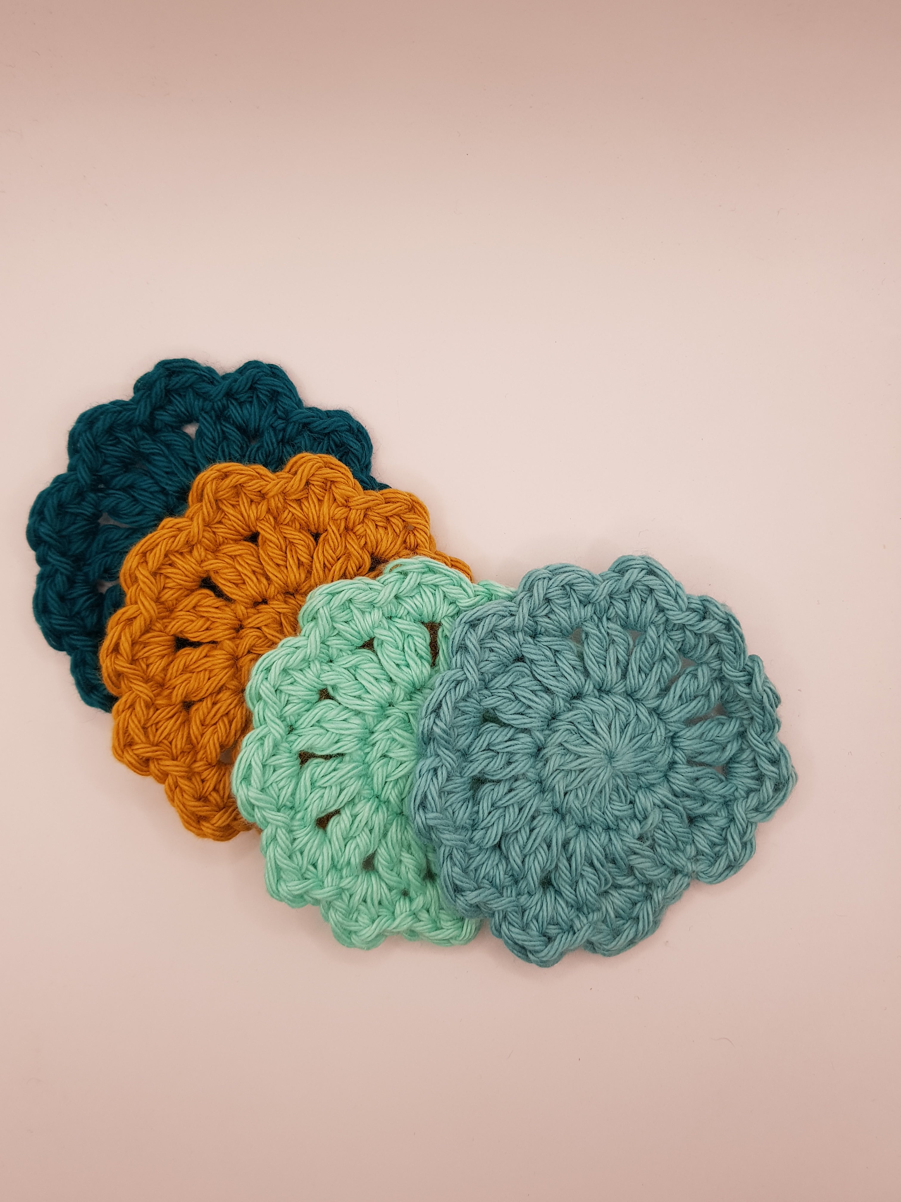 Title: Set of Four Crochet Face Scrubbies
Description: These crochet face scrubbies, crafted from soft cotton by the brand jean & andy, come in a set of four. With delicately scalloped edges and a color palette ranging from dark teal to gentle blue-green, they make an eco-friendly addition to your collection. Perfect against a neutral backdrop, they add charm and style to any space.