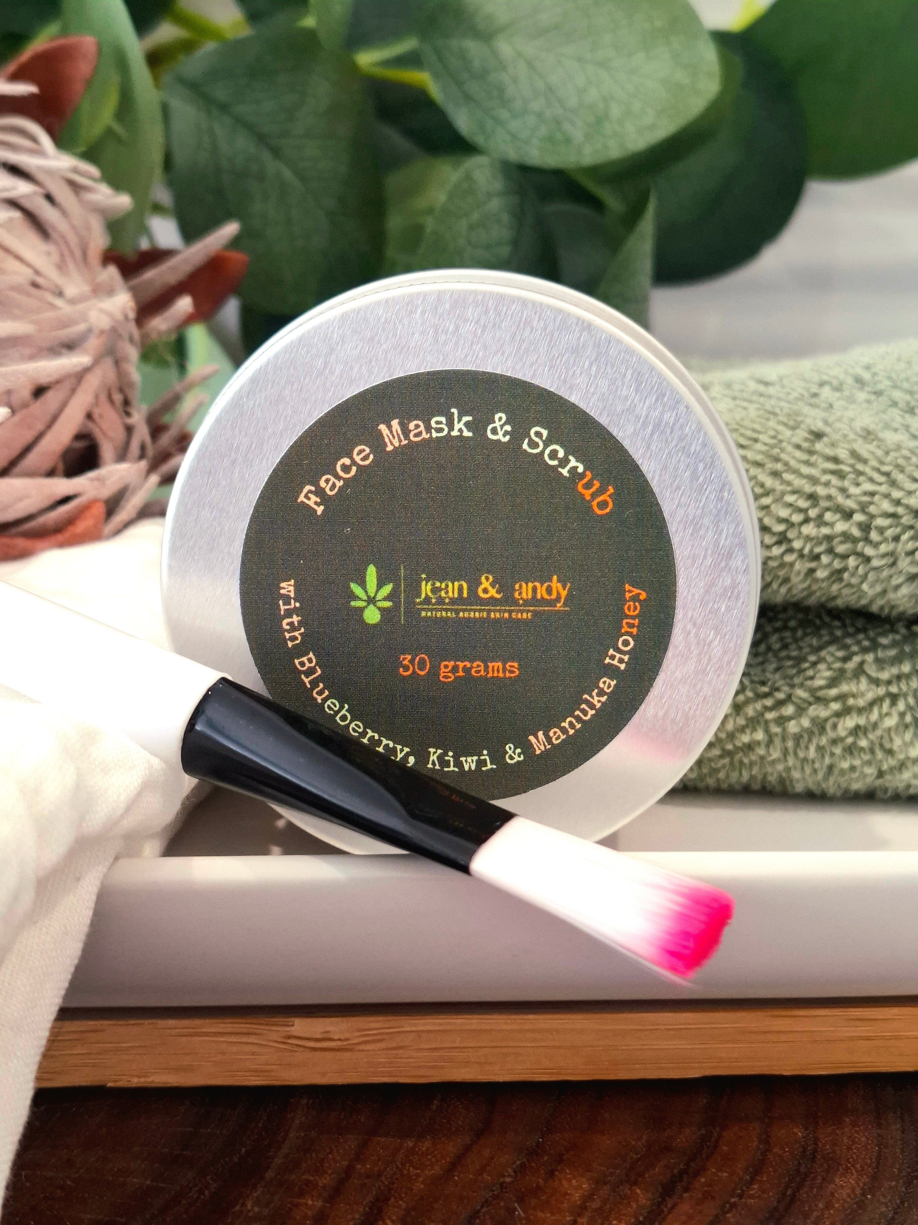 "A jar of luxurious face mask and scrub with a reusable mask brush, featuring ingredients like diatomaceous earth, kaolin clay, coconut milk powder, papaya, kiwi, blueberry powders, manuka honey extract, and portulaca extract for cleansing, exfoliating, and nourishing all skin types."