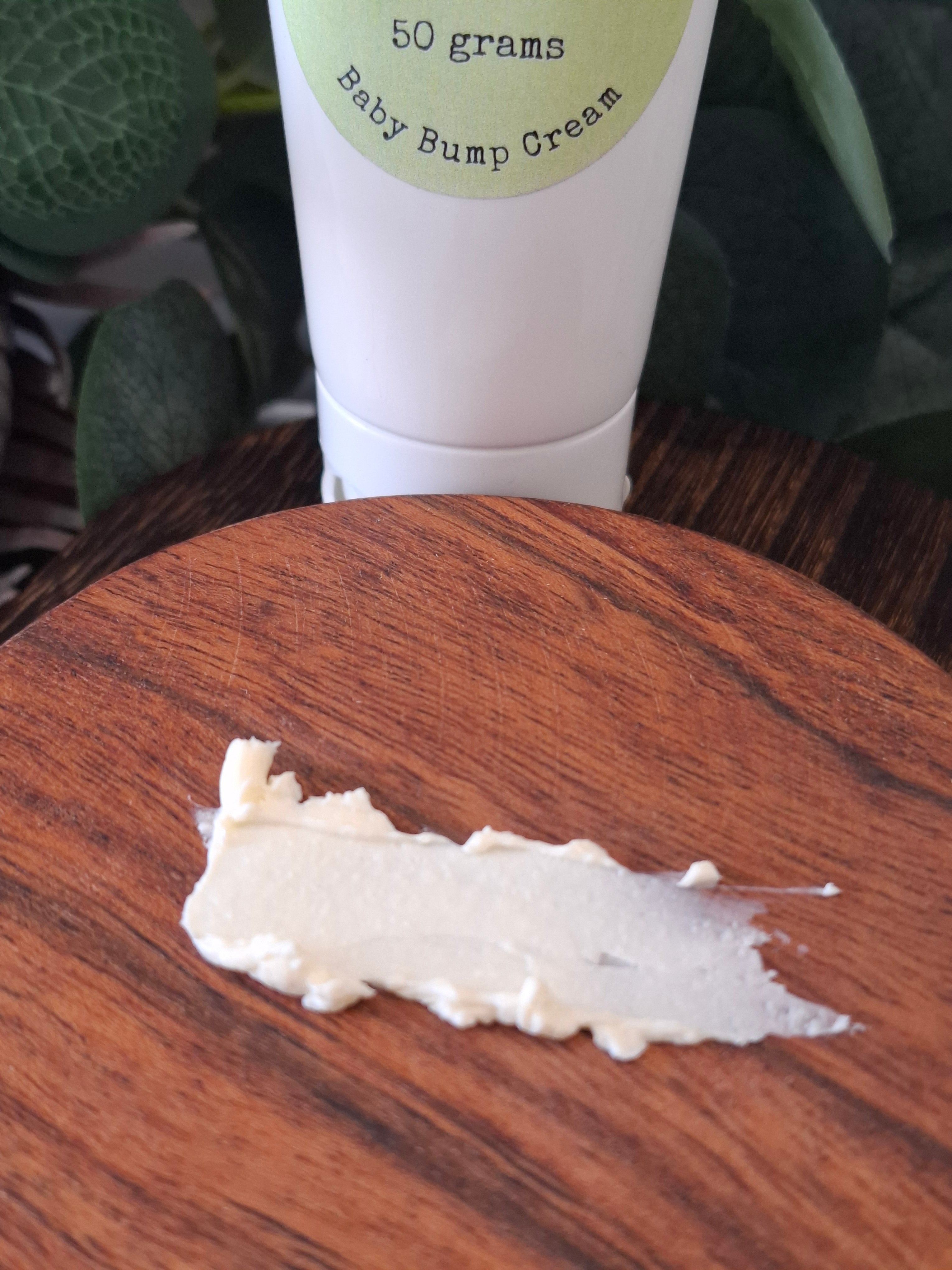 Tube of baby bump cream with a sample on a wooden surface