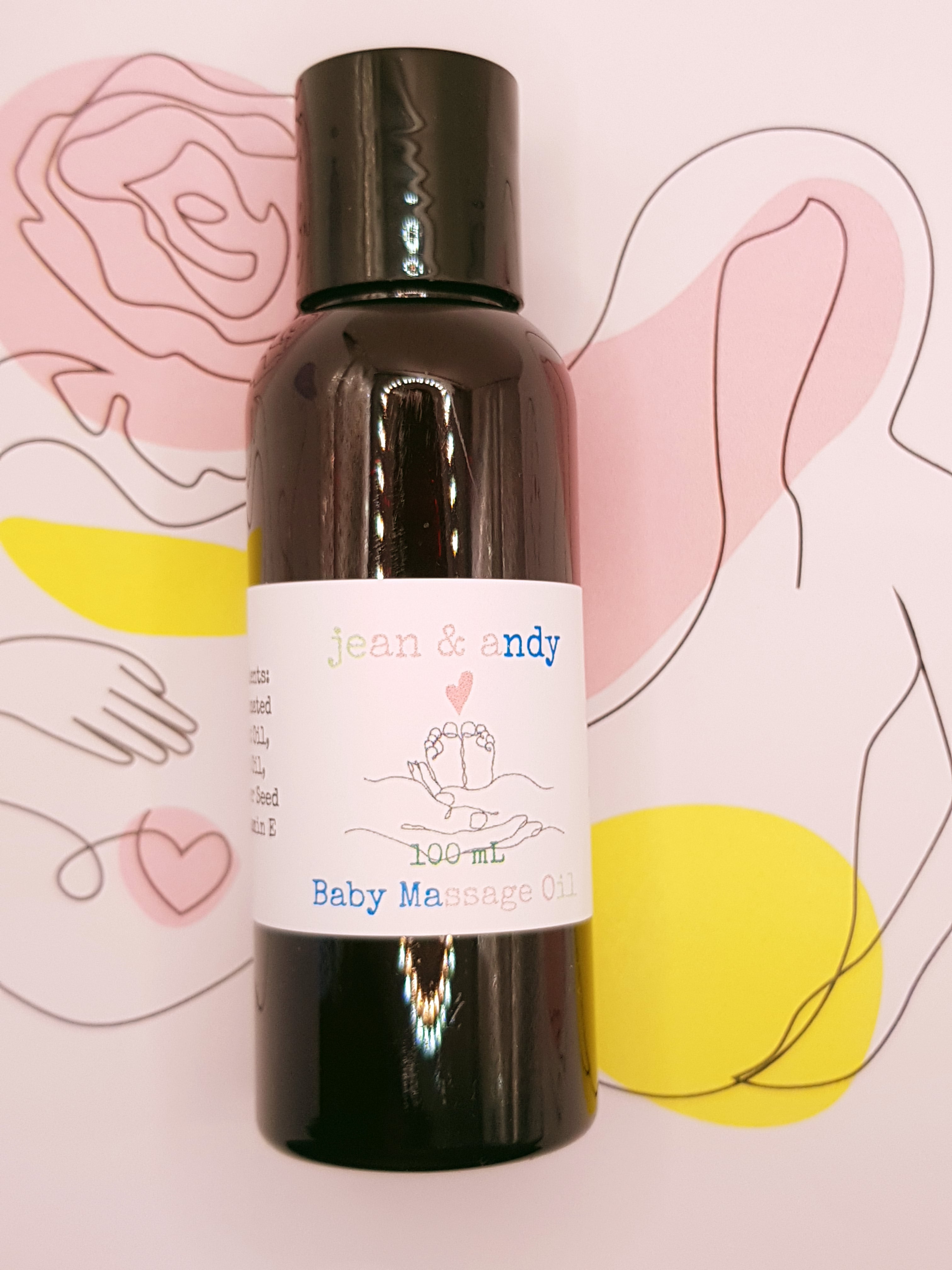 A dark bottle of jean & andy's Baby Massage Oil, featuring a white label, is set against a lively backdrop of abstract line art and pastel shapes, enhanced with the nourishing benefits of sunflower seed oil.