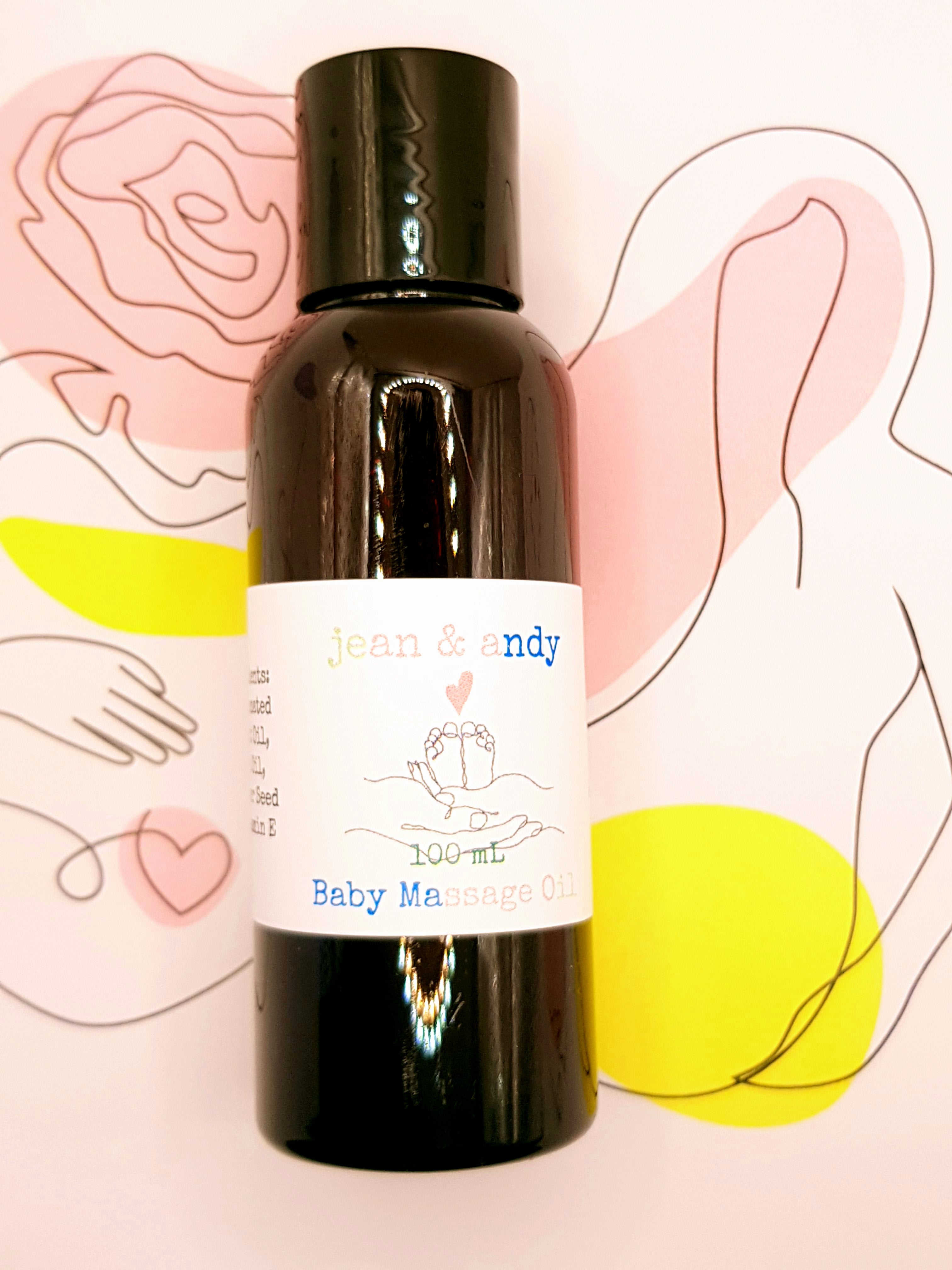 A 100 mL black bottle labeled with the brand name jean & andy, featuring their Baby Massage Oil, rests on a lively abstract background decorated with hand and flower outlines in pink, yellow, and white hues. This oil is infused with nourishing sunflower seed oil and fractionated coconut oil to provide your little one with a gentle touch.
